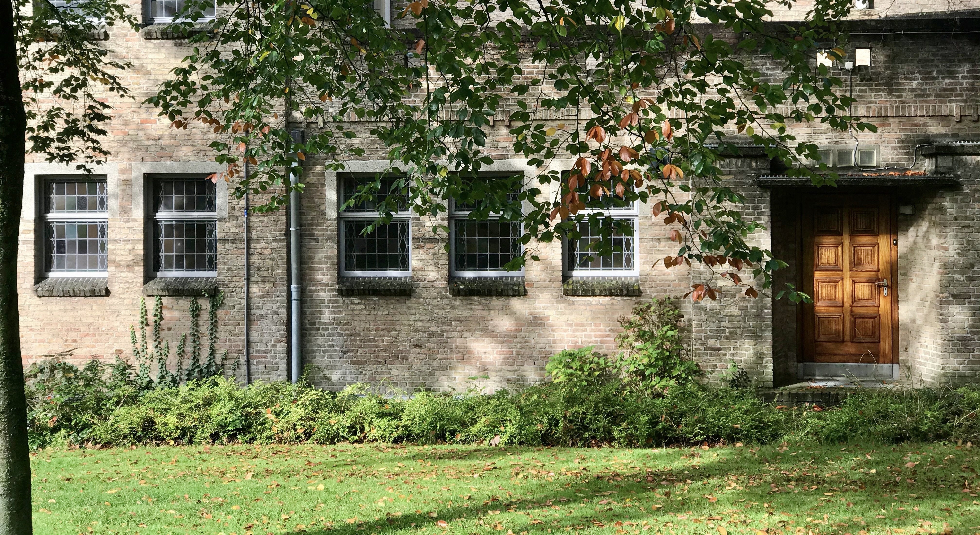 Don Boscokerk Venlo, gevel met glas-in-loodramen en houten deur